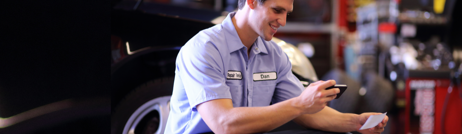 man in auto shop mobile depositing a check