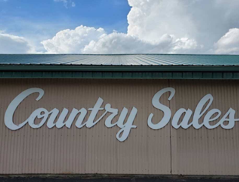 Large sign on the side of a building that reads "Country Sales"