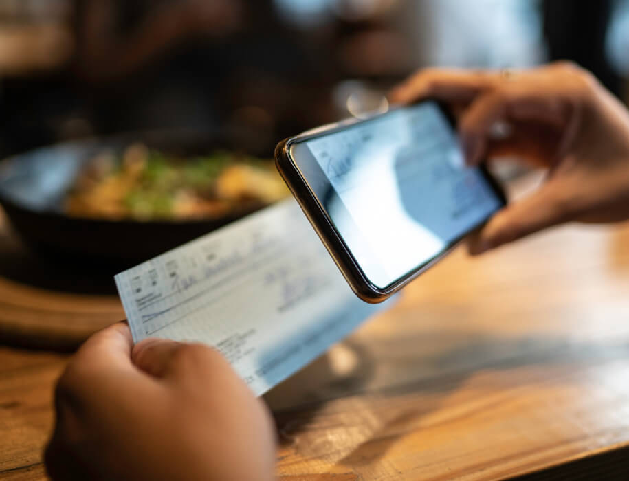 Close up of someone taking a picture of a bank check with their smartphone